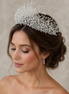 Woman wearing a sparkling tiara with a neutral background